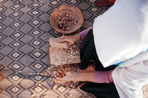 a woman holding a stone and a bowl of argan